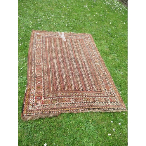 30 - An Eastern design carpet, with a red and beige ground with line field and a repeating boarder, 70ins... 