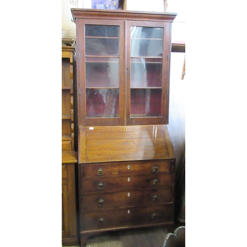 32 - A Georgian oak bureau, the sloping fall front fitted with drawers and pigeon holes, with long drawer... 