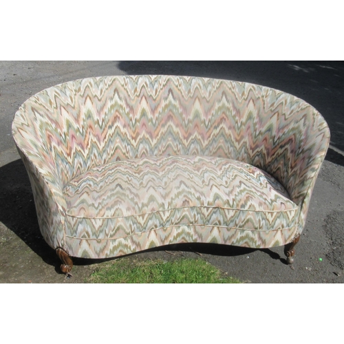 33A - An upholstered curved settee, on carved legs