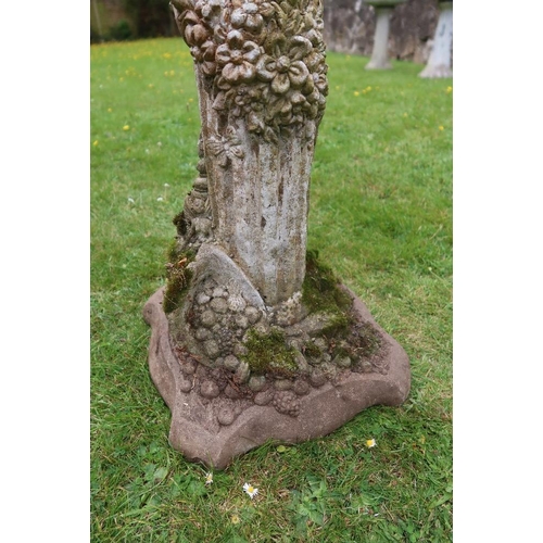 53 - A garden stone model, of an Eastern figure playing pan pipes on a column the column decorated with f... 