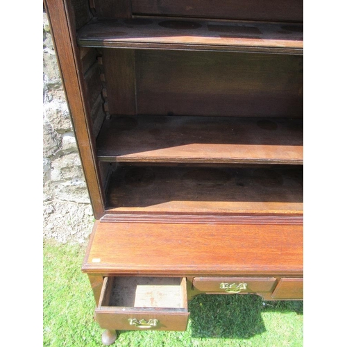 54 - (62) A low oak dresser with close boarded open shelves over fitted three drawers within a shaped fri... 