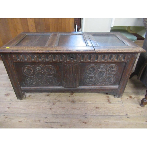 79C - An Antique oak coffer, with panelled lid and carved front, width 46ins