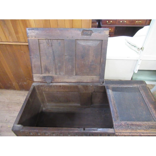 79C - An Antique oak coffer, with panelled lid and carved front, width 46ins