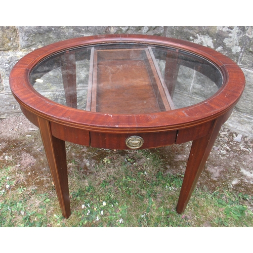 81A - An oval glass top coffee table, with a drawer, maximum diameter 27.5ins