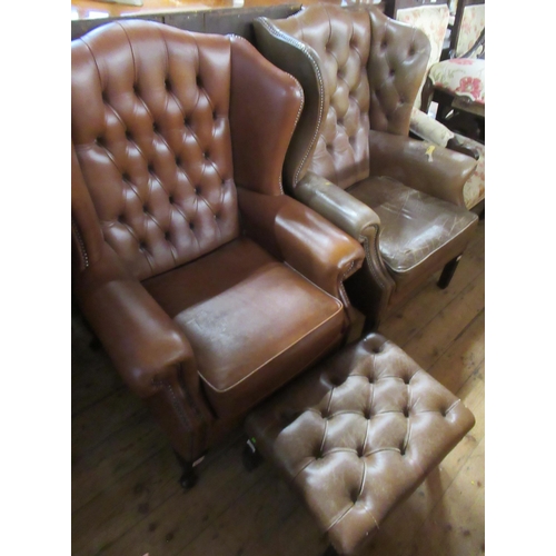 40 - Two wing back leather armchairs, together with a matching footstool, trade only