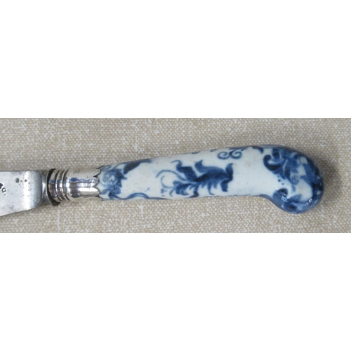 218 - An 18th century pistol grip dinner knife, with porcelain handle decorated in blue and white, the ste... 