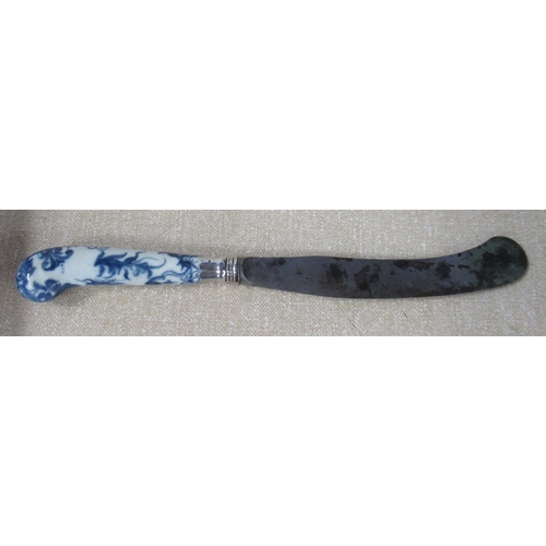 218 - An 18th century pistol grip dinner knife, with porcelain handle decorated in blue and white, the ste... 