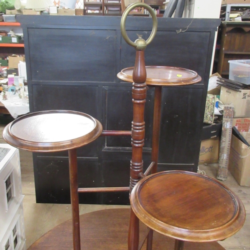 23 - A mahogany cake stand, with gilded brass ring handle and on gilded brass paw feet, height 33ins