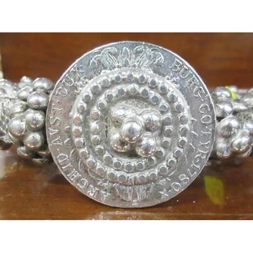 393 - A silver coloured bangle, set with a coin