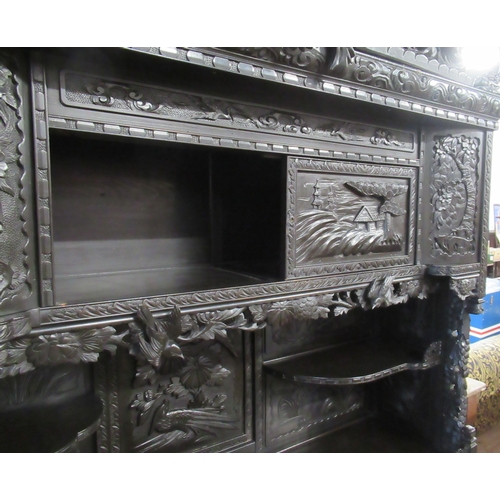 45 - An ebonised Chinese cabinet, fitted with cupboards and drawers, with carved decoration, height 86ins... 