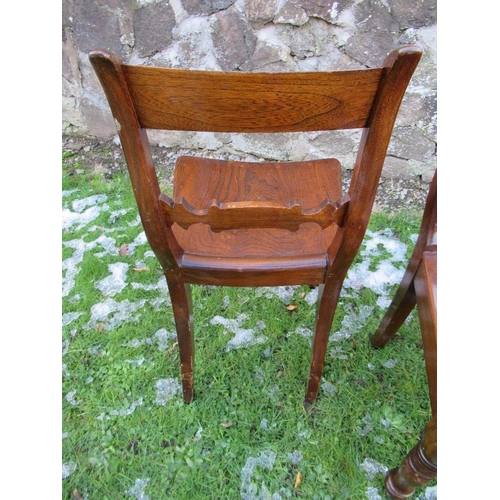 101 - A pair of 19th century stained oak saddle seat hall chairs raised on turned front legs