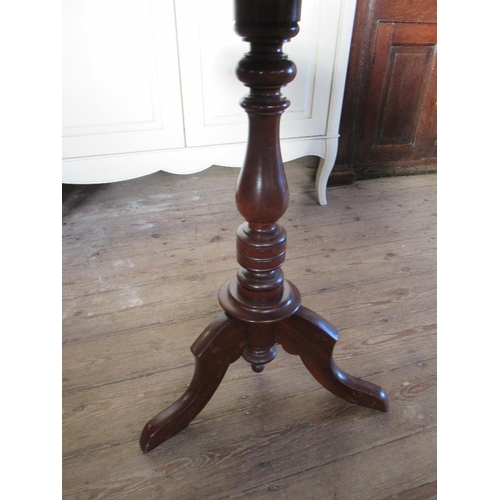 117 - A shaped occasional table raised on a tripod base max diameter 21ins, height 27.5ins