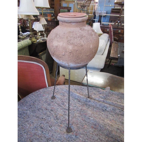 204 - A globular covered terracotta pot raised on a 3 leg metal stand height 28ins