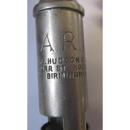 209 - ARP, two J Hudson & Co whistles, together with a badge