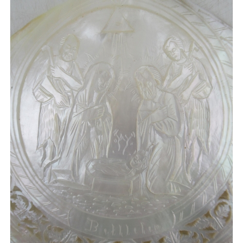 223 - A carved mother of pearl shell, carved with a scene of figures round a crib and titled Bethlehem