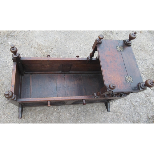 26 - An antique oak child's crib, with carved panels and a raising canopy, length 38ins