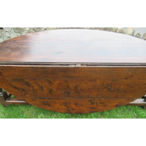 51 - An 18th century oak oval wake table, with double gate leg action, with turned legs and supports