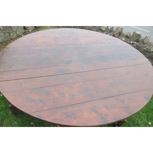 51 - An 18th century oak oval wake table, with double gate leg action, with turned legs and supports