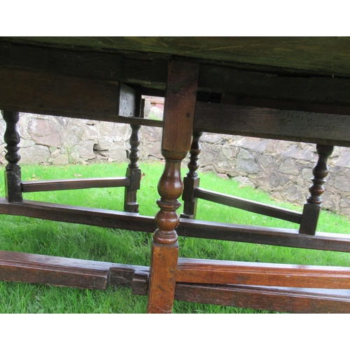 51 - An 18th century oak oval wake table, with double gate leg action, with turned legs and supports