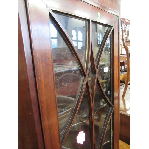 61 - A later Georgian mahogany corner cupboard with astragal glazing bars open to reveal shaped shelves, ... 