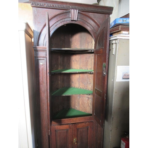 75 - An 18th century free standing four door oak corner cupboard, with two arched fielded panel doors ove... 