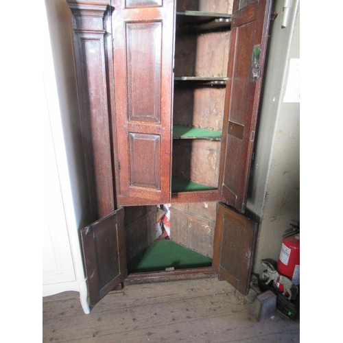 75 - An 18th century free standing four door oak corner cupboard, with two arched fielded panel doors ove... 