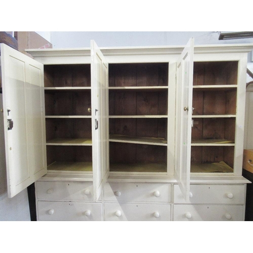 77 - A white painted 19th century pine house keepers cupboard the upper section having four paneled doors... 