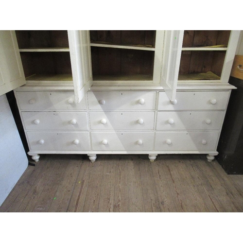 77 - A white painted 19th century pine house keepers cupboard the upper section having four paneled doors... 