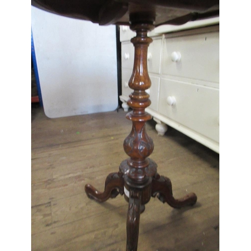 70 - A shaped occasional table raised on a tripod base max diameter 21ins, height 27.5ins