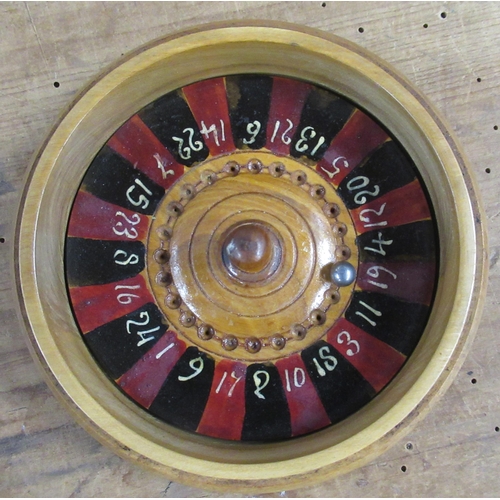 135 - A circular treen roulette wheel, the cover of the box decorated with swallows in flight, the interio... 