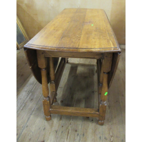 36 - An oak gateleg dining table, with oval top, 53ins x 67ins, height 29ins