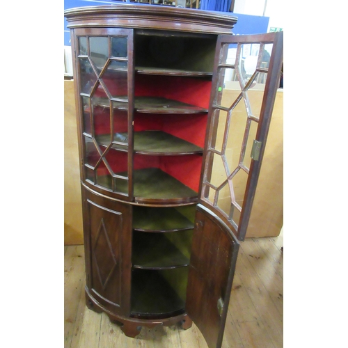 47A - A mahogany floor standing barrel fronted corner cabinet, with astragal glazed upper section and a pa... 