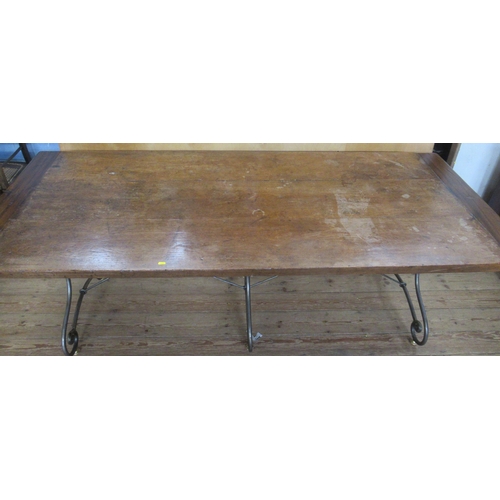 58 - A refectory style dining table, three plank top with cleated ends, on a metal scroll base, 87ins x 3... 