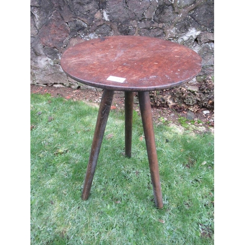 11 - A primitive style cricket table, raised on three slender legs diameter 16ins, height 27ins