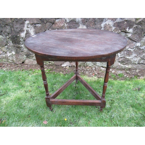 13 - An oak circular top cricket table raised on three turned legs united by stretchers diameter 29ins, h... 