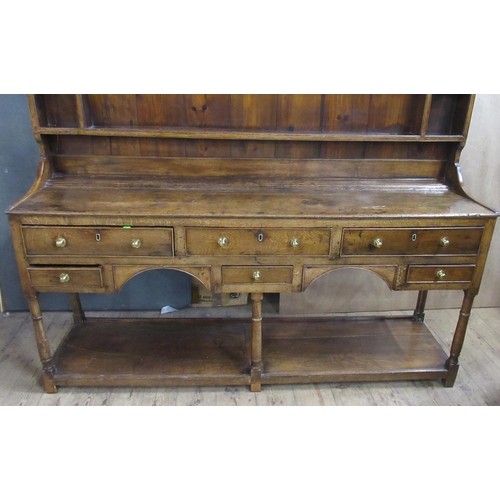 22 - An Antique oak dresser, the upper section fitted with shelves, the base fitted with six drawers, wit... 