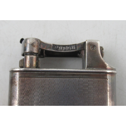 226A - A Dunhill silver mounted tallboy type lighter, with engine turned decoration, together with a set of... 