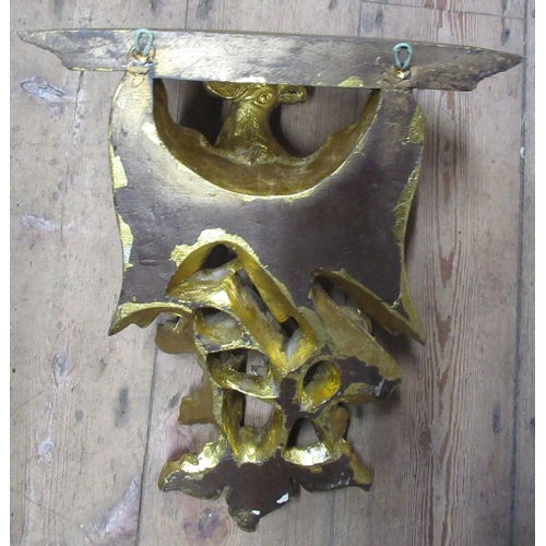 24 - A wooden gilt wall bracket, formed as a wing bird, on foliage supporting a shelf, 12.5ins x 16ins