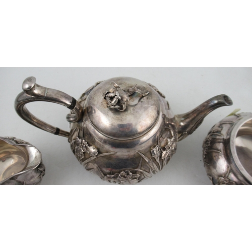 268 - A Japanese silver three piece tea set, decorated with iris's, marked Musashiya,  weight 41oz