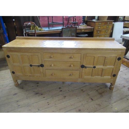 27 - A Robert Thompson Mouseman oak side board, having adzed top, with three graduated central drawers wi... 