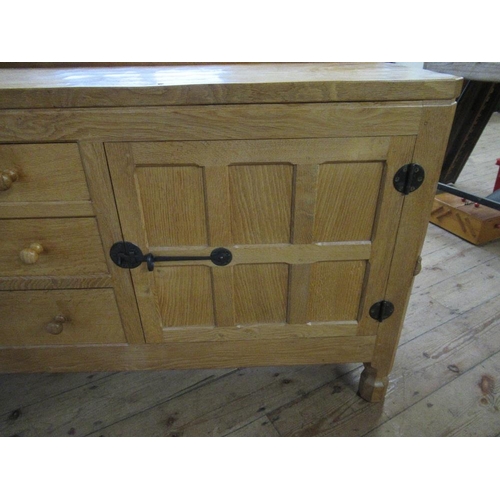 27 - A Robert Thompson Mouseman oak side board, having adzed top, with three graduated central drawers wi... 