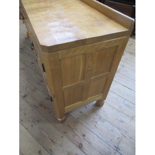 27 - A Robert Thompson Mouseman oak side board, having adzed top, with three graduated central drawers wi... 