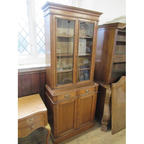 3 - An oak cabinet with glazed upper section over covered doors, width 36ins, height 83ins