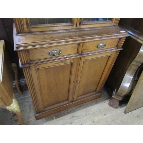 3 - An oak cabinet with glazed upper section over covered doors, width 36ins, height 83ins