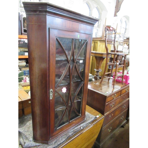 36 - A later Georgian mahogany corner cupboard with astragal glazing bars open to reveal shaped shelves, ... 