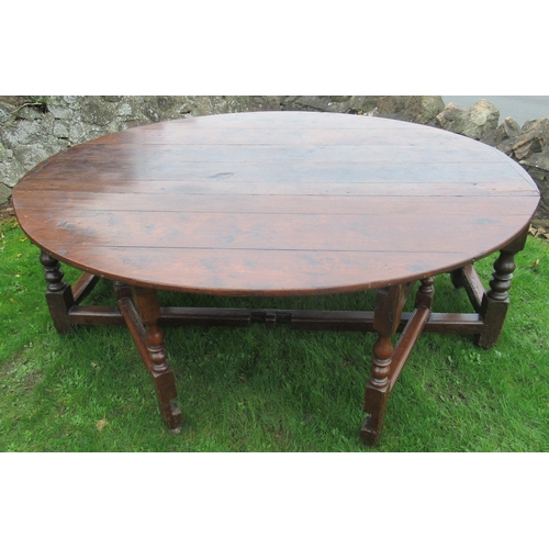 40 - An 18th century oak oval wake table, with double gate leg action, with turned legs and supports