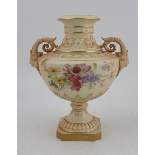 503 - A Royal Worcester blush ivory pedestal vase, decorated with field flowers, with scrolling mask handl... 