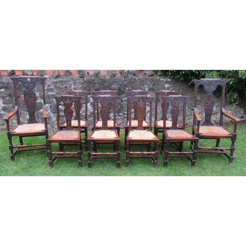 51 - A set of 10 (8+2) oak dining chairs, with foliate decoration with rushed seats