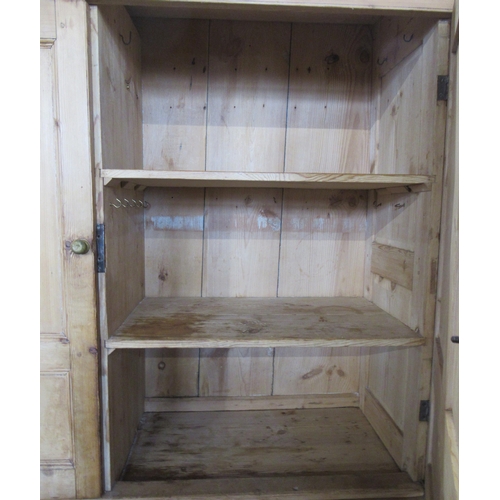 65 - A large pine kitchen cupboard, the upper section fitted with doors, opening to reveal shelves, with ... 