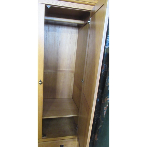 66 - A modern oak wardrobe, fitted with bezel drawer